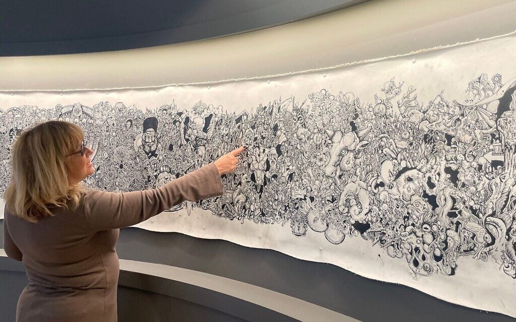 La directrice du Musée des terres bibliques, Risa Levitt, montre « Kuma », le rouleau illustré réalisé par Eitan Rosenzweig, un soldat tué le 22 novembre 2023 lors d'une bataille à Gaza, actuellement exposé au musée de Jérusalem jusqu'à l'été 2025. (Crédit : Jessica Steinberg/Times of Israel) La directrice du Musée des terres bibliques, Risa Levitt, montre « Kuma », le rouleau illustré réalisé par Eitan Rosenzweig, un soldat tué le 22 novembre 2023 lors d'une bataille à Gaza, actuellement exposé au musée de Jérusalem jusqu'à l'été 2025. (Crédit : Jessica Steinberg/Times of Israel)