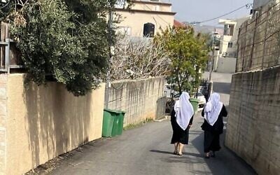 Illustration : Deux femmes druzes marchant dans une rue de Yarka, en Galilée occidentale, le 4 mars 2025. (Crédit : Diana Bletter/Times of Israel)