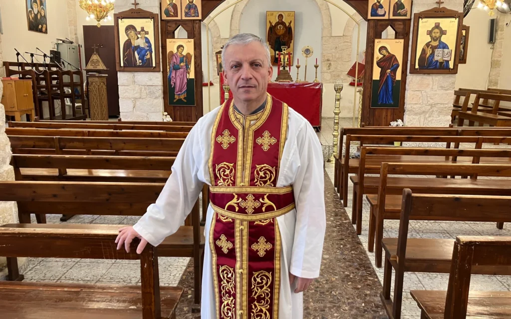 Le Père Michael Assi après la messe du dimanche matin à l'église Mar Elias à Fassuta le 23 mars 2025. (Crédit : Diana Bletter/Times of Israel)