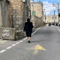 Une femme marche dans la rue à Fassuta le 23 mars 2025. (Crédit : Diana Bletter/Times of Israel)