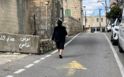 Une femme marche dans la rue à Fassuta le 23 mars 2025. (Crédit : Diana Bletter/Times of Israel)