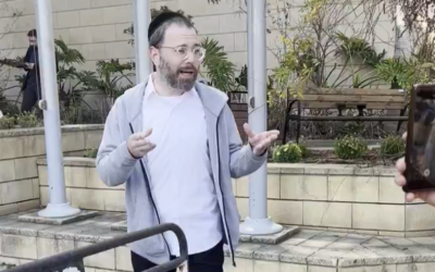 Le journaliste d'extrême gauche Israel Frey s'adresse à ses soutiens devant un commissariat de police à Tel Aviv, le 12 mars 2025. (Capture d'écran : X/Oren Ziv/used in accordance with Clause 27a of the Copyright Law)