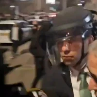 Le maire de Beit Shemesh, Shmuel Greenberg (avec le casque), est sauvé par la police d'une foule d'extrémistes ultra-orthodoxes, le 19 mars 2025. (Capture d'écran/X)