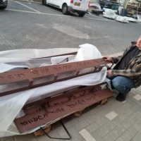 L'architecte Zvika Pasternak avec quelques-unes des bandes en métal sur lesquelles sont inscrites les signatures des 64 résidents assassinés au kibboutz Kfar Aza par des terroristes du Hamas le 7 octobre 2023. (Crédit : Zvika Pasternak)