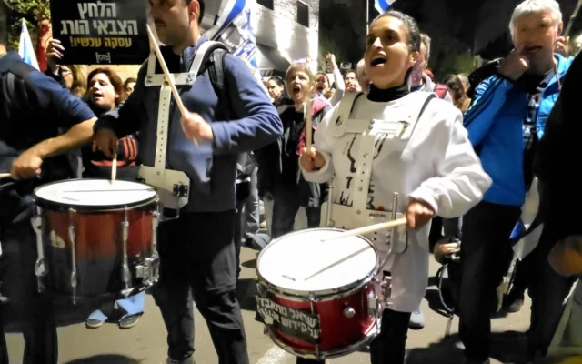 La chanteuse Achinoam Nini rejoint les batteurs lors de la manifestation du 24 mars 2025 près de la résidence du Premier ministre, rue Azza à Jérusalem. (Crédit : Zohar Bar-Yehuda/Mouvement de protestation pro-démocratie) La chanteuse Achinoam Nini rejoint les batteurs lors de la manifestation du 24 mars 2025 près de la résidence du Premier ministre, rue Azza à Jérusalem. (Crédit : Zohar Bar-Yehuda/Mouvement de protestation pro-démocratie)