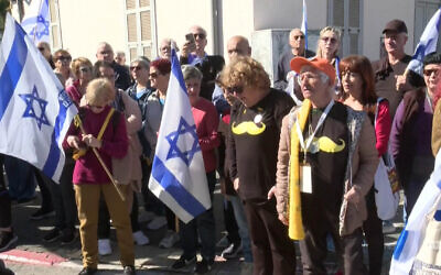 Des Israéliens rendent hommage à Shlomo Mantzur alors qu'ils se rassemblent à Rishon Lezion pour son cortège funèbre avant son enterrement au kibboutz Kissufim, le 2 mars 2025. (Nir Kafri/AFPTV/AFP)