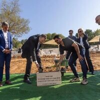 La ministre de la Culture et des Sports, Miki Zohar, à gauche, pose la première pierre d'un nouveau centre de judo nommé en l'honneur d'Omer Smadga, un réserviste de Tsahal tué au combat, à l'Institut Wingate, le 11 mars 2025. (Crédit : Institut Wingate)