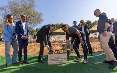 La ministre de la Culture et des Sports, Miki Zohar, à gauche, pose la première pierre d'un nouveau centre de judo nommé en l'honneur d'Omer Smadga, un réserviste de Tsahal tué au combat, à l'Institut Wingate, le 11 mars 2025. (Crédit : Institut Wingate)