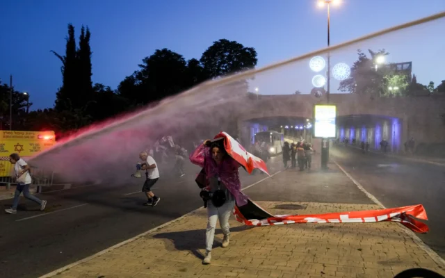La police utilise un liquide nauséabond pour disperser des manifestants qui bloquent une route lors d'une manifestation contre le gouvernement du Premier ministre Benjamin Netanyahu à Jérusalem, le 20 mai 2024. (Crédit : Mahmoud Illean/AP)