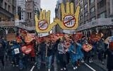 Des personnes défilent lors d'une manifestation « Hands Off ! » contre le président américain Donald Trump à New York, le 5 avril 2025. (Crédit : Andres Kudacki/AP)