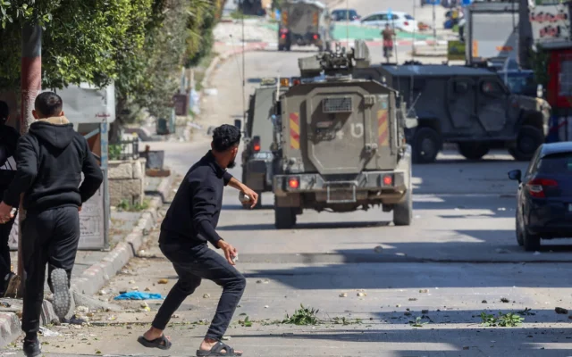 Des Palestiniens lancent des pierres sur les forces israéliennes lors d'un raid dans le camp de réfugiés de Balata en Cisjordanie, à l'est de Naplouse, le 24 mars 2025. Illustration (Crédit : Zain Jaafar / AFP)
