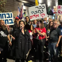 Noam Dan, une proche de l'otage libéré Ofer Calderon, s'adresse aux manifestants devant la résidence privée du Premier ministre Benjamin Netanyahu à Jérusalem, le 17 avril 2025. (Crédit : Charlie Summers/Times of Israel)
