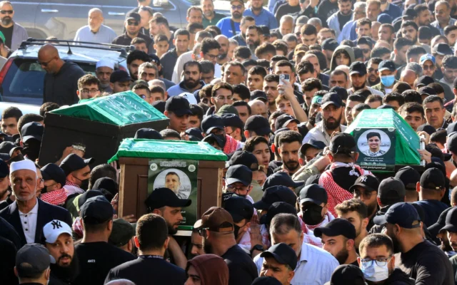 Des personnes en deuil transportent les cercueils du commandant du groupe terroriste Hamas Hassan Farhat (au centre), de son fils Hamza (à droite) et de sa fille Jenan (à gauche), tués lors d'une frappe israélienne qui a visé leur appartement dans la ville de Sidon, dans le sud du Liban, lors de leur cortège funèbre le 4 avril 2025. (Crédit : Mahmoud ZAYYAT / AFP)