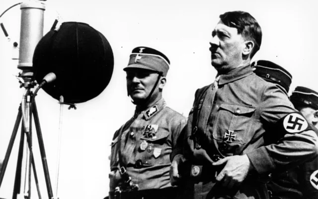 Illustration : Adolf Hitler s'adressant à 30 000 soldats nazis en uniforme, à Kiel, en Allemagne, le 7 mai 1933. (Crédit : AP)