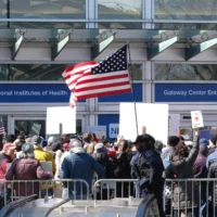 Des manifestants protestent contre les coupes budgétaires devant le National Institutes of Health (NIH) à Bethesda, dans le Maryland, le 8 mars 2025. (Crédit : Michael Mathes / AFP)