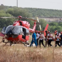 Des équipes de secours israéliennes évacuant un blessé par hélicoptère près de Sderot, dans le sud du pays, le 7 octobre 2023 (Crédit : Menahem Kahana/AFP)