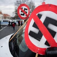 Illustration : un panneau d'interdiction avec une croix gammée visible sur le capot d'une voiture lors d'une manifestation près du parc des expositions de Dresde, en Allemagne, le 10 avril 2021. (Crédit : Jens Schlueter/AFP)