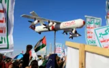 Un manifestant porte un faux drone lors d’une manifestation de soutien aux Palestiniens pendant la guerre entre Israël et le Hamas à Gaza, dans la capitale yéménite houthiste de Sanaa, le 23 février 2024. 'Samad 4' est écrit sur le côté du faux drone. (Mohammed Huwais/AFP)