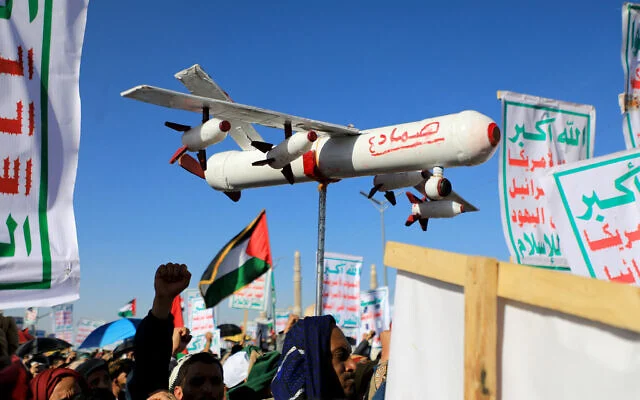 Un manifestant porte un faux drone lors d’une manifestation de soutien aux Palestiniens pendant la guerre entre Israël et le Hamas à Gaza, dans la capitale yéménite houthiste de Sanaa, le 23 février 2024. 'Samad 4' est écrit sur le côté du faux drone. (Mohammed Huwais/AFP) Un manifestant porte un faux drone lors d’une manifestation de soutien aux Palestiniens pendant la guerre entre Israël et le Hamas à Gaza, dans la capitale yéménite houthiste de Sanaa, le 23 février 2024. 'Samad 4' est écrit sur le côté du faux drone. (Mohammed Huwais/AFP)