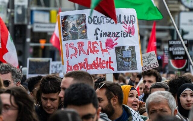Un manifestant affiche une pancarte sur laquelle on peut lire : « L'Allemagne finance, Israël bombarde » lors d'une manifestation pro-palestinienne et anti-israélienne à Berlin le 19 octobre 2024. (Crédit : John Macdougall/AFP) Un manifestant affiche une pancarte sur laquelle on peut lire : « L'Allemagne finance, Israël bombarde » lors d'une manifestation pro-palestinienne et anti-israélienne à Berlin le 19 octobre 2024. (Crédit : John Macdougall/AFP)