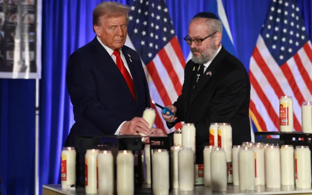 Donald Trump et le rabbin Yehuda Kaploun allument une bougie lors d'un événement commémoratif du 7-Octobre au Trump National Doral Golf Club, le 7 octobre 2024, à Doral, en Floride. (Crédit : Joe Raedle/Getty Images/AFP)