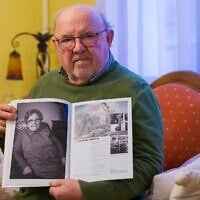 Guy Poirot, né le 11 mars 1945 au camp de concentration de Ravensbrück, pose avec un portrait de sa mère tiré du livre « De la résistance » à Nancy, dans le nord-est de la France, le 10 décembre 2024. (Jean-Christophe Verhaegen/AFP)