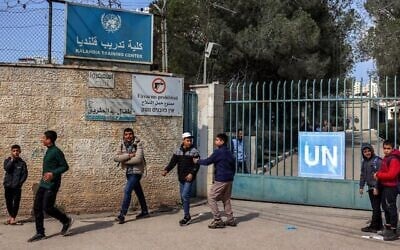 Des enfants se rassemblent devant le portail du Centre de formation de Kalandia, géré par l’Office de secours et de travaux des Nations unies pour les réfugiés de Palestine, attaqué dans la journée par les forces israéliennes, le 18 février 2025. (Zain Jaafar / AFP)