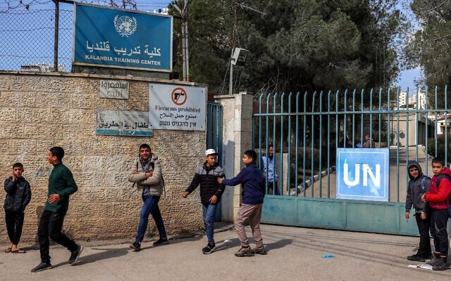 Des enfants se rassemblent devant le portail du Centre de formation de Kalandia, géré par l’Office de secours et de travaux des Nations unies pour les réfugiés de Palestine, attaqué dans la journée par les forces israéliennes, le 18 février 2025. (Zain Jaafar / AFP)
