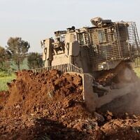 Un bulldozer D9 sans pilote creusant un champ lors d'une démonstration à la presse, dans les locaux d'Israel Aerospace Industries (IAI), près de Tel Aviv, le 26 mars 2025. (Crédit : Gil Cohen-Magen/AFP)