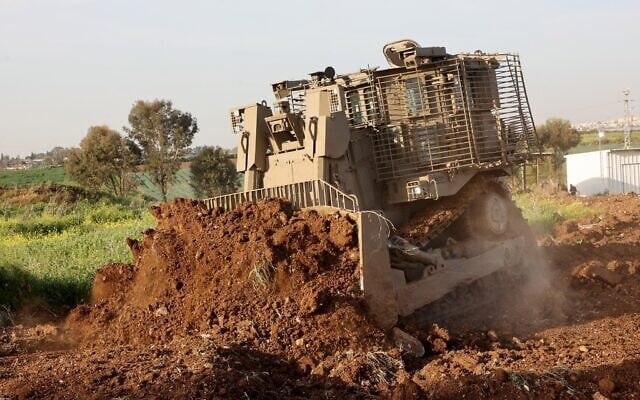Un bulldozer D9 sans pilote creusant un champ lors d'une démonstration à la presse, dans les locaux d'Israel Aerospace Industries (IAI), près de Tel Aviv, le 26 mars 2025. (Crédit : Gil Cohen-Magen/AFP)