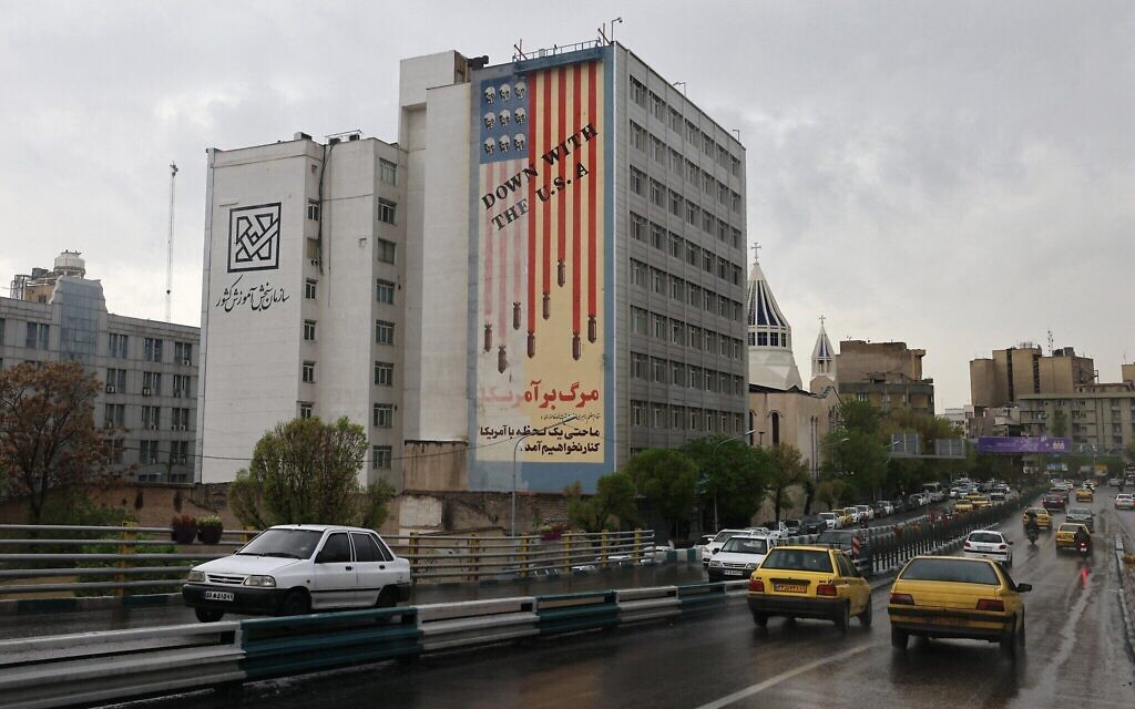 Des automobilistes passant devant une fresque anti-américaine peinte sur le côté d'un bâtiment, à Téhéran, le 5 avril 2025. (Crédit : Atta Kenare/AFP)