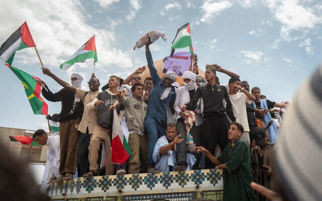 Un manifestant tient un faux sac mortuaire aux côtés d'autres manifestants devant la réplique de la mosquée Al-Aqsa au rond-point de Jérusalem, lors d'une manifestation pro-palestinienne près de l'ambassade des États-Unis à Nouakchott, en Mauritanie, le 7 avril 2025. (Crédit : MICHELE CATTANI / AFP) Un manifestant tient un faux sac mortuaire aux côtés d'autres manifestants devant la réplique de la mosquée Al-Aqsa au rond-point de Jérusalem, lors d'une manifestation pro-palestinienne près de l'ambassade des États-Unis à Nouakchott, en Mauritanie, le 7 avril 2025. (Crédit : MICHELE CATTANI / AFP)