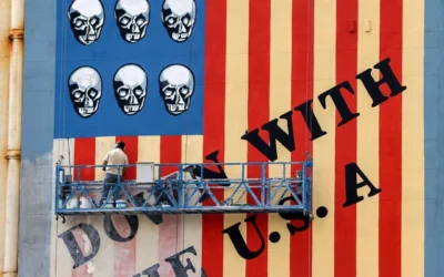 Un homme sur une plateforme appliquant une nouvelle couche de peinture sur la célèbre fresque anti-américaine dessinée sur le mur d'un immeuble de l'avenue Karim Khan Zand avec le slogan « À bas les États-Unis » et des crânes remplaçant les étoiles du drapeau américain, à Téhéran, le 8 avril 2025 . (Crédit : Atta Kenare/AFP)