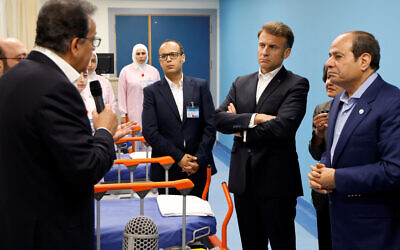 Le président égyptien Abdel Fattah al-Sisi, à droite, et le président français Emmanuel Macron, à gauche, écoutent le personnel médical dans un service destiné aux patients palestiniens à l'hôpital El Arish, dans la ville égyptienne d'Arish (nord-est de la péninsule du Sinaï), à environ 55 kilomètres à l'ouest de la frontière avec la bande de Gaza, le 8 avril 2025. (Crédit :  Ludovic MARIN / POOL / AFP)