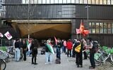 Des personnes se rassemblent devant l'Institut d'études politiques (Sciences-Po) de Strasbourg, certaines enveloppées dans un drapeau palestinien, alors que l'université doit voter sur le maintien ou non de son partenariat avec l'université Reichman à Herzliya, en Israël, le 8 avril 2025. (Crédit : Frederick FLORIN / AFP)