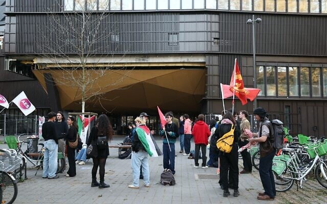 Des personnes se rassemblent devant l'Institut d'études politiques (Sciences-Po) de Strasbourg, certaines enveloppées dans un drapeau palestinien, alors que l'université doit voter sur le maintien ou non de son partenariat avec l'université Reichman à Herzliya, en Israël, le 8 avril 2025. (Crédit : Frederick FLORIN / AFP) Des personnes se rassemblent devant l'Institut d'études politiques (Sciences-Po) de Strasbourg, certaines enveloppées dans un drapeau palestinien, alors que l'université doit voter sur le maintien ou non de son partenariat avec l'université Reichman à Herzliya, en Israël, le 8 avril 2025. (Crédit : Frederick FLORIN / AFP)