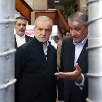 Le président Masoud Pezeshkian (à gauche) et le chef de l'Organisation iranienne de l'énergie atomique (AEOI), Mohammad Eslami, lors de la « Journée nationale de la technologie nucléaire », à Téhéran, le 9 avril 2025. (Crédit : Présidence iranienne/AFP)