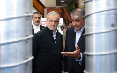 Le président Masoud Pezeshkian (à gauche) et le chef de l'Organisation iranienne de l'énergie atomique (AEOI), Mohammad Eslami, lors de la « Journée nationale de la technologie nucléaire », à Téhéran, le 9 avril 2025. (Crédit : Présidence iranienne/AFP)