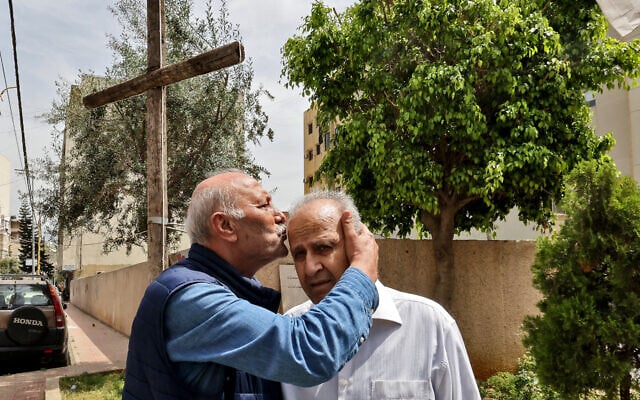 L'ancien combattant du Parti communiste libanais Nassim Assad (à gauche) embrasse le front de l'ancien combattant du Parti phalangiste chrétien libanais, le commandant Georges Mazraani, alors qu'ils revisitent une ancienne zone de la ligne verte dans le district d'Ain al-Remmaneh, dans la banlieue sud de Beyrouth, le 9 avril 2025. Près des lignes de front où ils s'affrontaient autrefois, d'anciens combattants de la guerre civile libanaise se rassemblent aujourd'hui pour porter le même message : plus jamais ça, un demi-siècle après l'éclatement de ce conflit dévastateur. (Crédit : Anwar AMRO/AFP) L'ancien combattant du Parti communiste libanais Nassim Assad (à gauche) embrasse le front de l'ancien combattant du Parti phalangiste chrétien libanais, le commandant Georges Mazraani, alors qu'ils revisitent une ancienne zone de la ligne verte dans le district d'Ain al-Remmaneh, dans la banlieue sud de Beyrouth, le 9 avril 2025. Près des lignes de front où ils s'affrontaient autrefois, d'anciens combattants de la guerre civile libanaise se rassemblent aujourd'hui pour porter le même message : plus jamais ça, un demi-siècle après l'éclatement de ce conflit dévastateur. (Crédit : Anwar AMRO/AFP)
