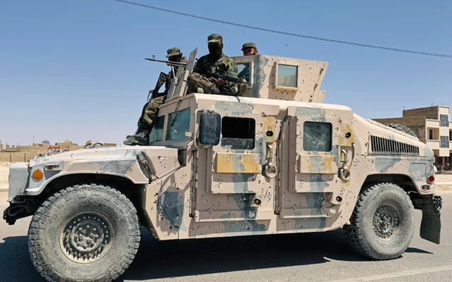 Des Talibans patrouillent le long de la route à bord d'un véhicule humvee après l'exécution publique d'un homme dans un stade de football à Zaranj, dans la province de Nimruz, en Afghanistan, le 11 avril 2025. (Crédit : AFP)