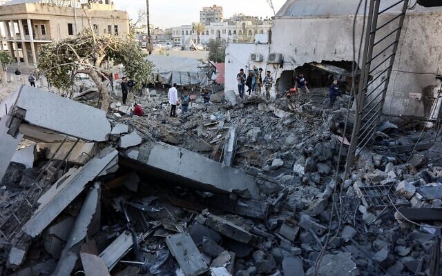 Des personnes examinent des ruines après une frappe israélienne sur l'hôpital Al-Ahli, dans la ville de Gaza, le 13 avril 2025.(Crédit : Omar AL-QATTAA/AFP) Des personnes examinent des ruines après une frappe israélienne sur l'hôpital Al-Ahli, dans la ville de Gaza, le 13 avril 2025.(Crédit : Omar AL-QATTAA/AFP)