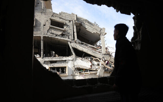 Un adolescent regardant à travers la fenêtre d'un bâtiment endommagé après des frappes israéliennes nocturnes sur un quartier résidentiel de Nazla, dans le sud-ouest de Jabaliya, dans le nord de la bande de Gaza, le 16 avril 2025. (Crédit : Bashar Taleb/AFP) Un adolescent regardant à travers la fenêtre d'un bâtiment endommagé après des frappes israéliennes nocturnes sur un quartier résidentiel de Nazla, dans le sud-ouest de Jabaliya, dans le nord de la bande de Gaza, le 16 avril 2025. (Crédit : Bashar Taleb/AFP)