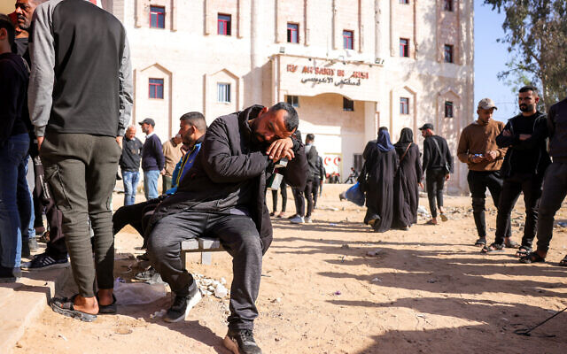 Un homme se repose sur un banc alors que des personnes attendent devant l'hôpital indonésien de Beit Lahia, dans le nord de la bande de Gaza, le 18 avril 2025. (Crédit : Bashar Taleb/AFP)