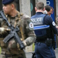 Des militaires français de l'opération Sentinelle et des agents de la police municipale se tiennent devant le lycée Notre-Dame de Toutes-Aides, où un élève a tué un autre élève et en a blessé trois autres lors d'une attaque au couteau, à Nantes, dans l'ouest de la France, le 24 avril 2025. Un élève armé d'un couteau a attaqué quatre de ses camarades avant d'être maîtrisé par le personnel enseignant, selon des informations obtenues par l'AFP auprès d'une source proche du dossier. (Crédit : Loic VENANCE / AFP)