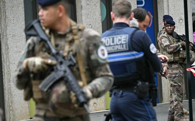 Des militaires français de l'opération Sentinelle et des agents de la police municipale se tiennent devant le lycée Notre-Dame de Toutes-Aides, où un élève a tué un autre élève et en a blessé trois autres lors d'une attaque au couteau, à Nantes, dans l'ouest de la France, le 24 avril 2025. Un élève armé d'un couteau a attaqué quatre de ses camarades avant d'être maîtrisé par le personnel enseignant, selon des informations obtenues par l'AFP auprès d'une source proche du dossier. (Crédit : Loic VENANCE / AFP)