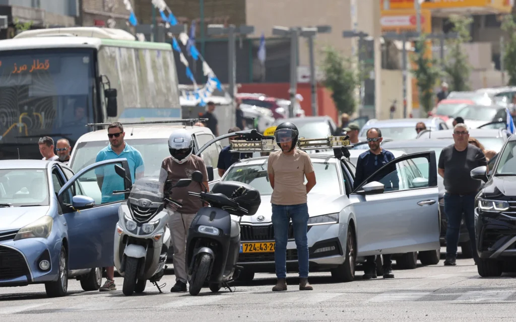 Des Israéliens observent deux minutes de silence à côté de leurs véhicules, alors que les sirènes retentissent dans tout le pays à l'occasion de Yom HaZikaron, le 30 avril 2025. (Jack GUEZ / AFP)