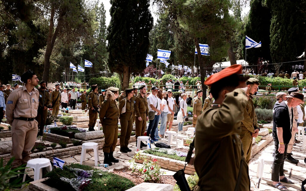 Des soldats israéliens et des personnes en deuil observant deux minutes de silence lors de la commémoration du Jour du Souvenir pour les soldats tombés au combat, au cimetière militaire du mont Herzl, à Jérusalem, le 30 avril 2025. (Crédit : Menahem Kahana/AFP)