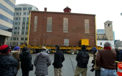 Illustration : Des badauds regardent des ouvriers déplacer la synagogue Adas Israel, la plus ancienne synagogue de Washington, vers un nouvel emplacement plus bas dans la rue, pour accueillir le Musée juif de la capitale, le 9 janvier 2019, à Washington, DC. (Crédit : AP Photo/Jose Luis Magana)