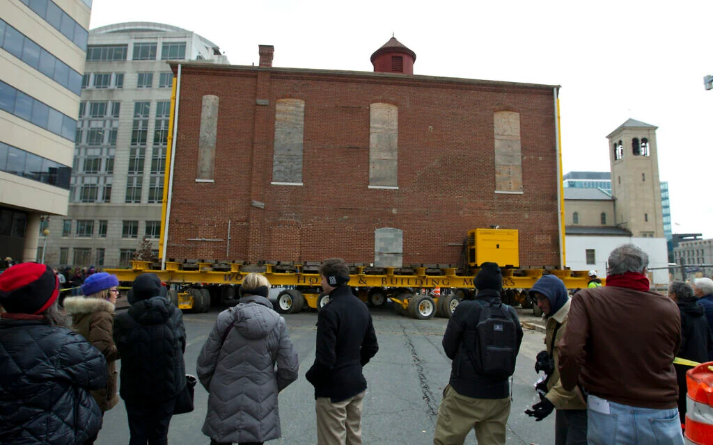 Illustration : Des badauds regardent des ouvriers déplacer la synagogue Adas Israel, la plus ancienne synagogue de Washington, vers un nouvel emplacement plus bas dans la rue, pour accueillir le Musée juif de la capitale, le 9 janvier 2019, à Washington, DC. (Crédit : AP Photo/Jose Luis Magana) Illustration : Des badauds regardent des ouvriers déplacer la synagogue Adas Israel, la plus ancienne synagogue de Washington, vers un nouvel emplacement plus bas dans la rue, pour accueillir le Musée juif de la capitale, le 9 janvier 2019, à Washington, DC. (Crédit : AP Photo/Jose Luis Magana)