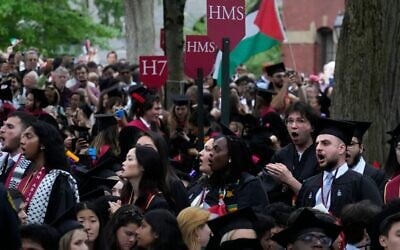 Des étudiants diplômés scandant des slogans alors qu'ils quittent la cérémonie de remise des diplômes en signe de protestation pour les treize diplômés de dernière année qui n'ont pas été autorisés à y participer en raison de leurs activités de protestation,  lors de la cérémonie de remise des diplômes de l'Université de Harvard, à Cambridge, dans le Massachusetts, le 23 mai 2024. (Crédit : Charles Krupa/AP)